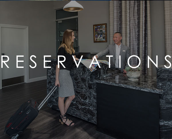 image of front desk making reservation for guest. Words on the image say "Reservation"